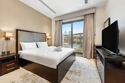 a bedroom with a large bed and a television at Full burj Khalifa view chic Studio in Dubai
