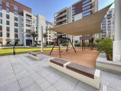a park with a bench and a swing at Stylish Dubai Stay 1BR, Lagoon, Pool, Gym in Dubai