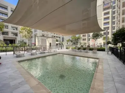a large swimming pool in a building with an umbrella at Stylish Dubai Stay 1BR, Lagoon, Pool, Gym in Dubai