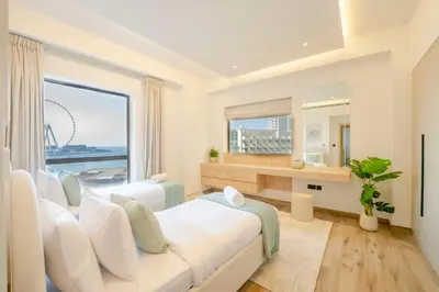 a bedroom with a large white bed and a large window at EasyGo - Luxury 3BR with Maid's Room, Dubai Eye View, JBR in Dubai