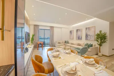 a dining room and living room with a table and chairs at EasyGo - Luxury 3BR with Maid's Room, Dubai Eye View, JBR in Dubai