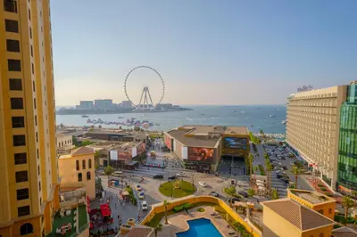 a city with a ferris wheel in the background at EasyGo - Luxury 3BR with Maid's Room, Dubai Eye View, JBR in Dubai