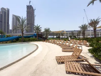 a beach with chaise lounges and a water park at GuestReady - 1BR | Creek Beach Getaway in Dubai