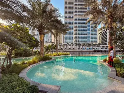 a swimming pool with palm trees in a city at GuestReady - 1BR | Creek Beach Getaway in Dubai