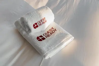 a towel with the words guest brain on a bed at GuestReady - 1BR | High-Floor Skyline Elegance in Dubai