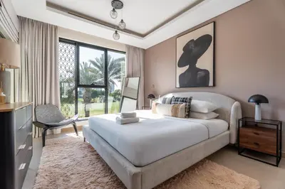a bedroom with a large bed and a television at GuestReady - Private 4BR Villa | Golf Course View in Dubai