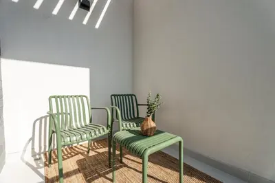 two green chairs and a table with a vase on it at GuestReady - Private 4BR Villa | Golf Course View in Dubai