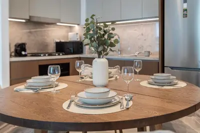a wooden table with plates and glasses and a vase at 1BR at Beach Isle Tower Emaar Beach front by EE Holiday Homes in Dubai