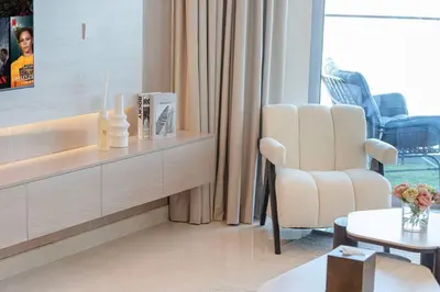 a living room with a chair and a table at Mahogany 22 - 4BR 16PAX - Burj Khalifa View Central in Dubai