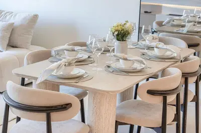 a wooden table with chairs and plates and wine glasses at Mahogany 22 - 4BR 16PAX - Burj Khalifa View Central in Dubai