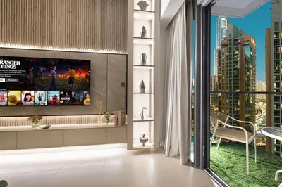 a living room with a tv and a large window at Mahogany 23 - 2BR 10PAX - Burj Khalifa View Central in Dubai