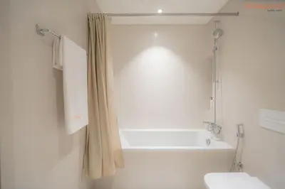 a white bathroom with a tub and a toilet at Beach vibes with Serene views in Dubai