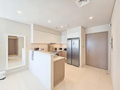 a large kitchen with white cabinets and a refrigerator at Full Burj Khalifa & Fountain Views - Luxury 2BR in Downtown Dubai in Dubai