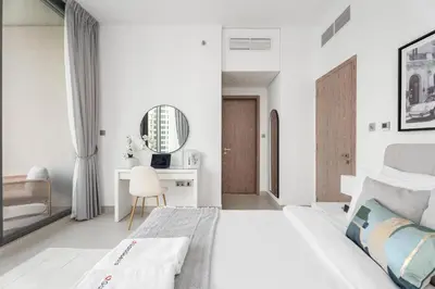 a white bedroom with a bed and a desk at Gala Guests - LIV Contemporary Marina View Apartment Collection in Dubai