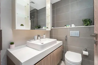 a bathroom with a white sink and a toilet at Gala Guests - LIV Contemporary Marina View Apartment Collection in Dubai