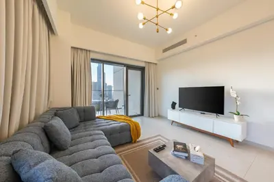 a living room with a large couch and a flat screen tv at Burj Royale Luxury 3BR Apartment in Dubai