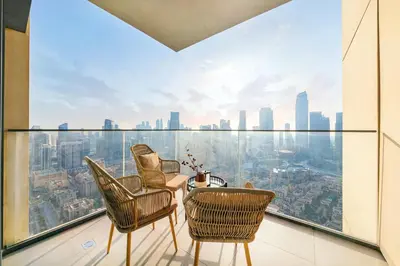 a room with chairs and a table and a view of the city at Burj Royale Luxury 3BR Apartment in Dubai