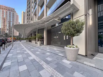 a sidewalk with potted plants and an awning on a building at 1BR with Full burj khalifa and fountain view in Dubai