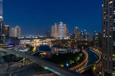 a view of a city at night with buildings at 1BR with Full burj khalifa and fountain view in Dubai