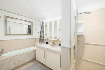 a bathroom with a tub and a sink and a mirror at South Ridge By Luxe Living - Full Burj Khalifa View in Dubai