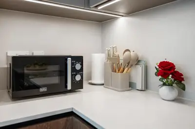 a kitchen counter with a microwave and utensils at BLVD-Manhattan Vibes 4BR High Floor Creek in Dubai