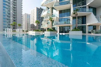 a swimming pool in front of a building at Premium 1BR Suite at Binghatti Royale with City Views in Dubai