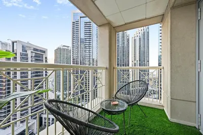 a balcony with two chairs and a table at Luxury 1BR, Long Stays & Walk to Burj Khalifa, High Speed Internet in Dubai