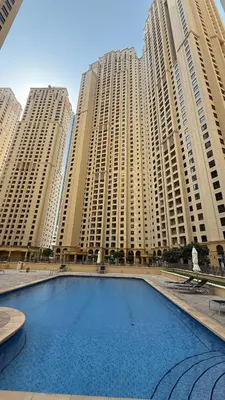 a large swimming pool in front of tall buildings at 2BR Beach Side Lux JBR Retreat - Luxury Pool Bahar in Dubai