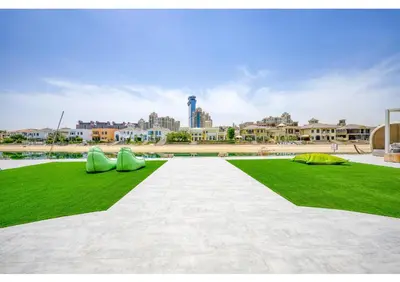 a park with green grass and two green slides at Signature Palm Villa Ultra-Luxury 5 BDR Retreat in Dubai