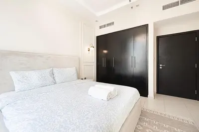 a bedroom with a white bed with a black door at 2BR Near to Beach JBR Dubai Eye & Sea View SV 2805 in Dubai