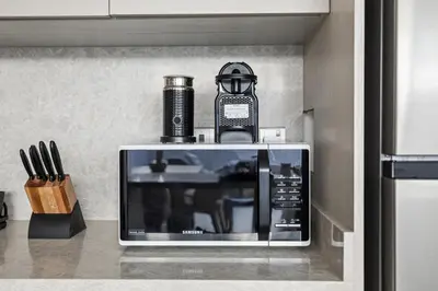 a microwave sitting on top of a kitchen counter at Family 4BR Villa | PS5 & Garden | New Community in Dubai