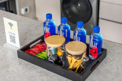 a tray with bottles of soda and snacks on a counter at Family 4BR Villa | PS5 & Garden | New Community in Dubai