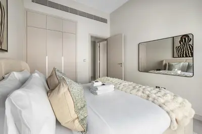 a living room with a white couch and a mirror at Family 4BR Villa | PS5 & Garden | New Community in Dubai