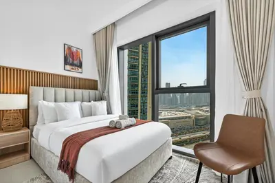 a hotel room with a bed and a large window at 2BR Burj View - Downtown Views 2 - Dubai Mall Access in Dubai