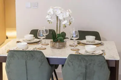 a table with plates and glasses and a plant on it at 1BR VIDA Dubai Mall - LUXURY DOWNTOWN DUBAI STAY - NAMUVE in Dubai