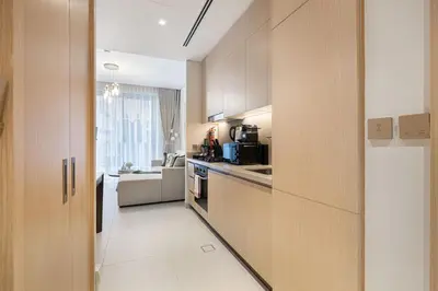 a kitchen with wooden cabinets and a counter top at 1BR VIDA Dubai Mall - LUXURY DOWNTOWN DUBAI STAY - NAMUVE in Dubai