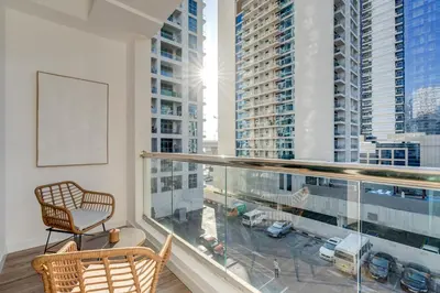 a balcony with a chair and a view of a city at Urban Chic 1Bedroom in DEC Tower Marina in Dubai