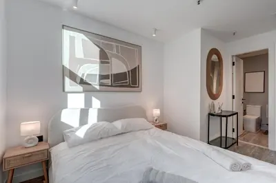 a white bedroom with a bed and a mirror at Urban Chic 1Bedroom in DEC Tower Marina in Dubai