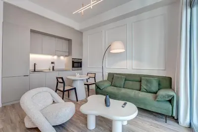 a living room with a green couch and a table at Urban Chic 1Bedroom in DEC Tower Marina in Dubai