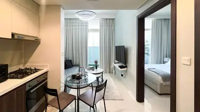 a kitchen and a living room with a table in a room at Modern 1-Bedroom Luxury Stay with Lake View in Reva, Business Bay in Dubai
