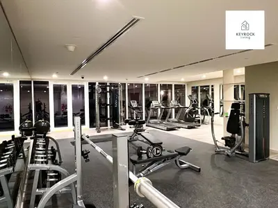 a gym with several treadmills and elliptical machines at Modern 1-Bedroom Luxury Stay with Lake View in Reva, Business Bay in Dubai