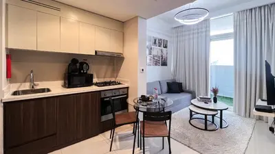 a kitchen and living room with a table and a couch at Modern 1-Bedroom Luxury Stay with Lake View in Reva, Business Bay in Dubai
