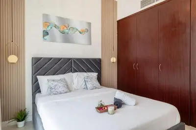 a bedroom with a white bed with a wooden headboard at Luxury 3 BR w Private Jacuzzi in Marina DEC 2203 in Dubai