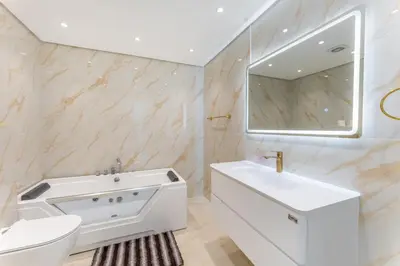 a white bathroom with a sink and a mirror at Luxury 3 BR w Private Jacuzzi in Marina DEC 2203 in Dubai