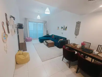 a living room with a blue couch and a table at Private Room with Bath in Dubai