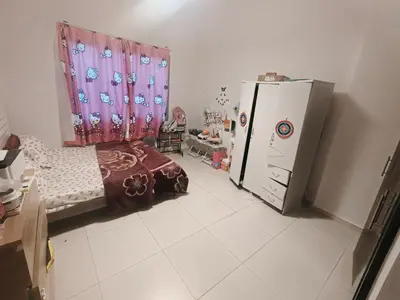 a room with a bed and a refrigerator in it at Private Room with Bath in Dubai