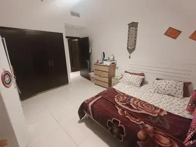 a bedroom with a bed and a dresser at Private Room with Bath in Dubai
