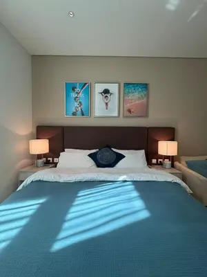 a bedroom with a large bed with two lamps at Studio in Seven Palm in Dubai