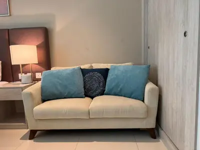 a couch with two blue pillows in a living room at Studio in Seven Palm in Dubai