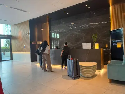two people standing in a lobby with their luggage at Studio in Seven Palm in Dubai
